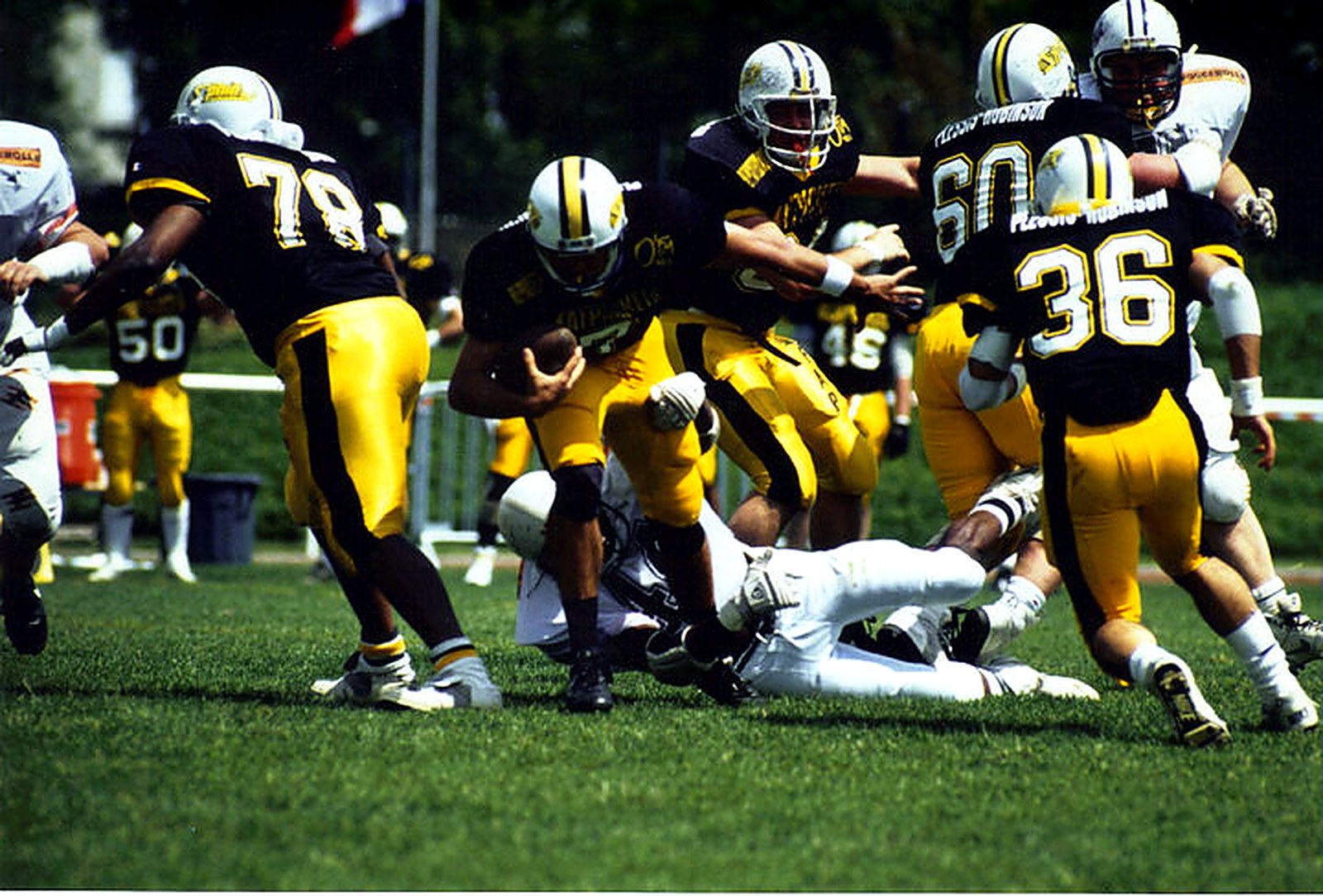 Action de jeu des Sphinx du Plessis-Robinson en noir et or, maillots floqués Plessis-Robinson, football américain français des années 1990